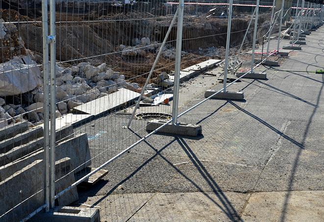 a group of temporary fence panels being used to create a privacy barrier on a job site